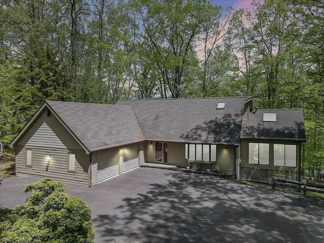 a aerial view of a house with a yard and large tree
