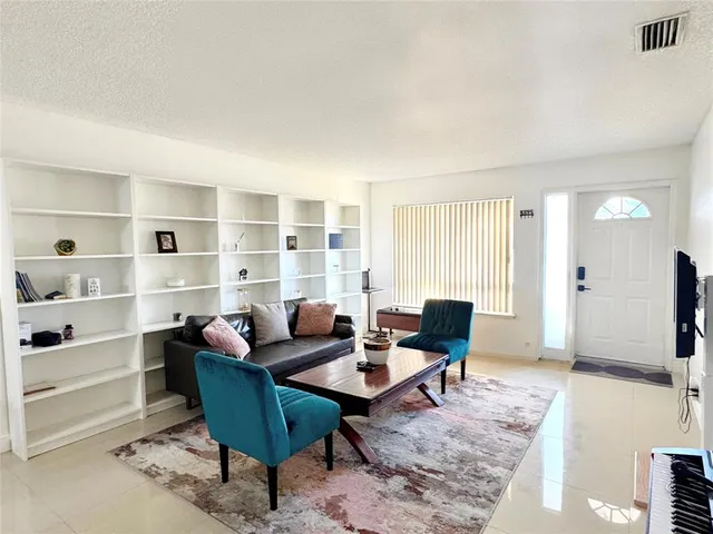 a living room with furniture a rug and white walls