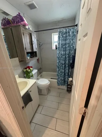 a bathroom with a sink a toilet and shower curtain