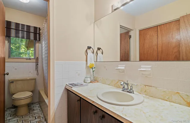 a bathroom with a granite countertop sink toilet and a mirror