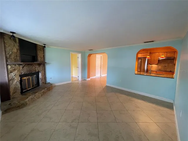 a view of an empty room with a fireplace and a flat screen tv
