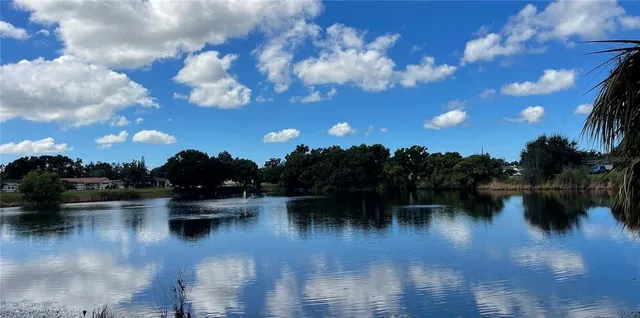 a view of house with yard and lake view