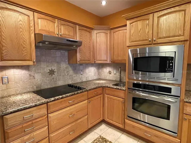 a kitchen with granite countertop cabinets stainless steel appliances and a sink