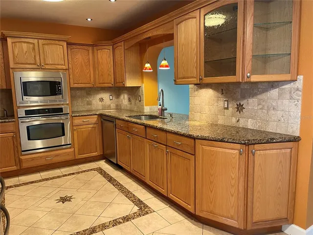 a kitchen with granite countertop stainless steel appliances a stove sink and microwave