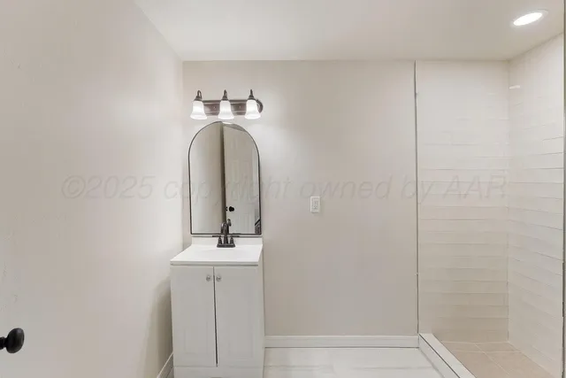 a bathroom with a sink a mirror and shower
