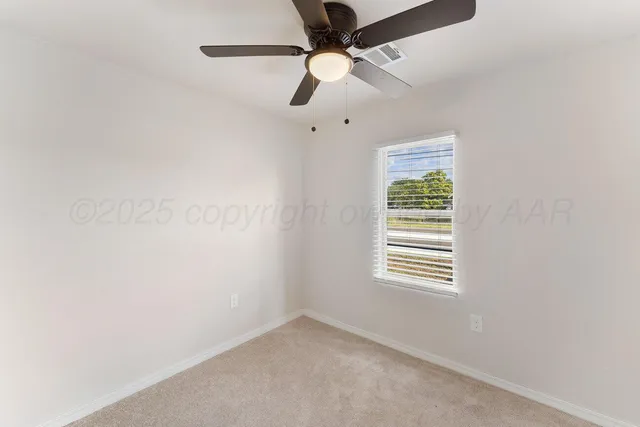 an empty room with a window and a fan