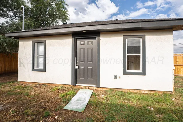 a view of a house with a yard and large tree