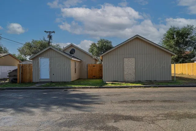 a view of backyard with small cabin and wooden fencing