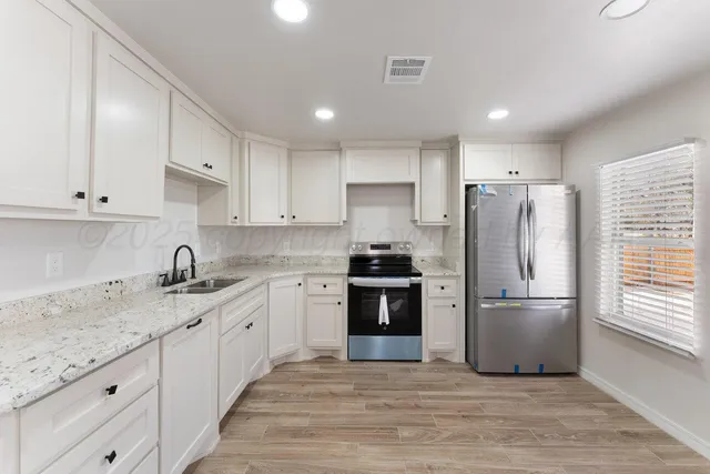 a kitchen with a refrigerator sink and cabinets