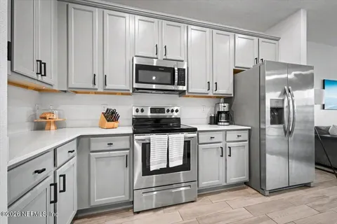 a kitchen with cabinets stainless steel appliances and a counter space