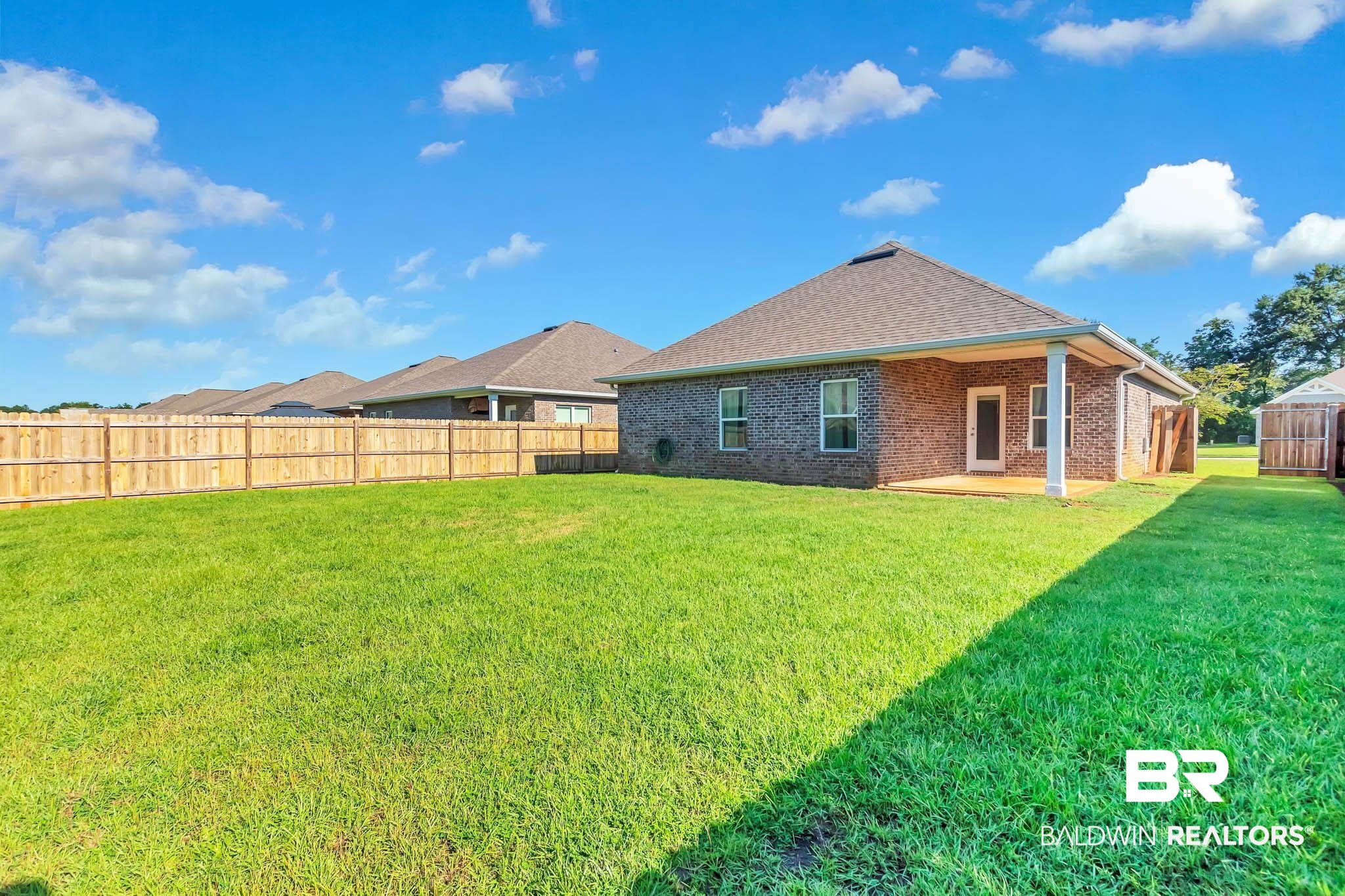 16461 Prado Loop Loxley, AL 36551 - Photo 59 of 78 Back of property with brick siding, a patio area, and roof with shingles