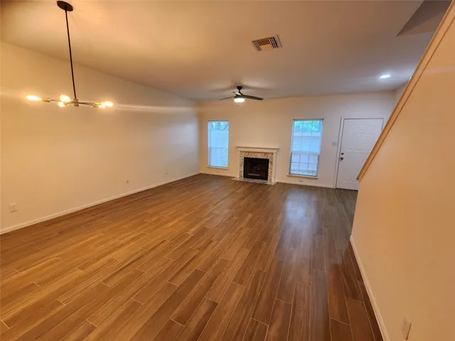 a view of empty room with wooden floor and fireplace