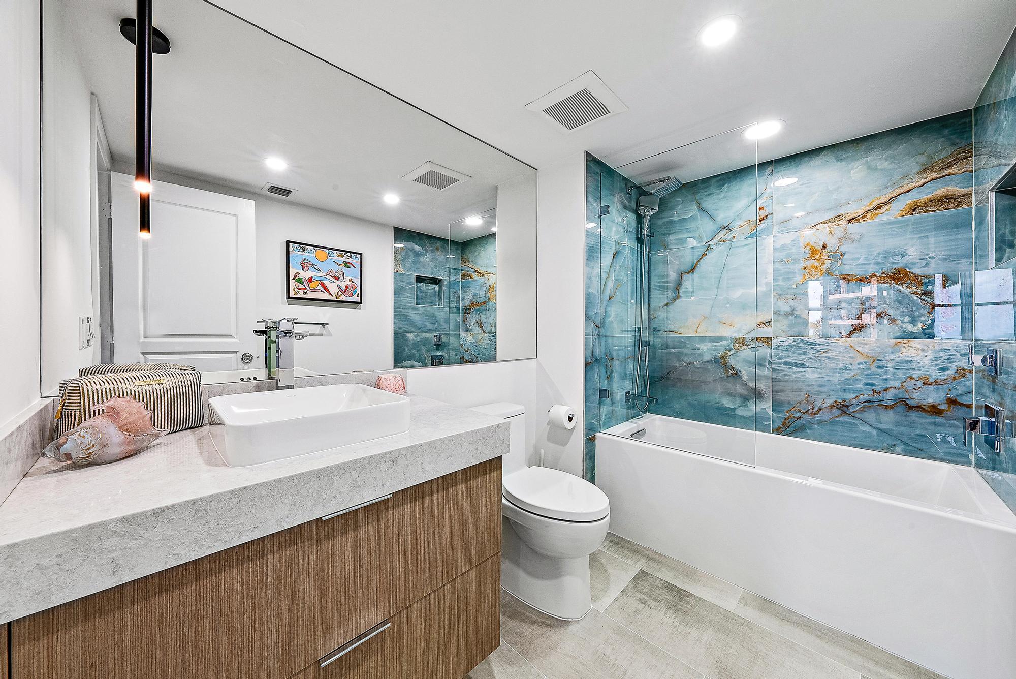 500 Ocean Drive, Unit E2A Juno Beach, FL 33408 - Photo 21 of 40 a bathroom with a granite countertop sink a toilet a bathtub and shower