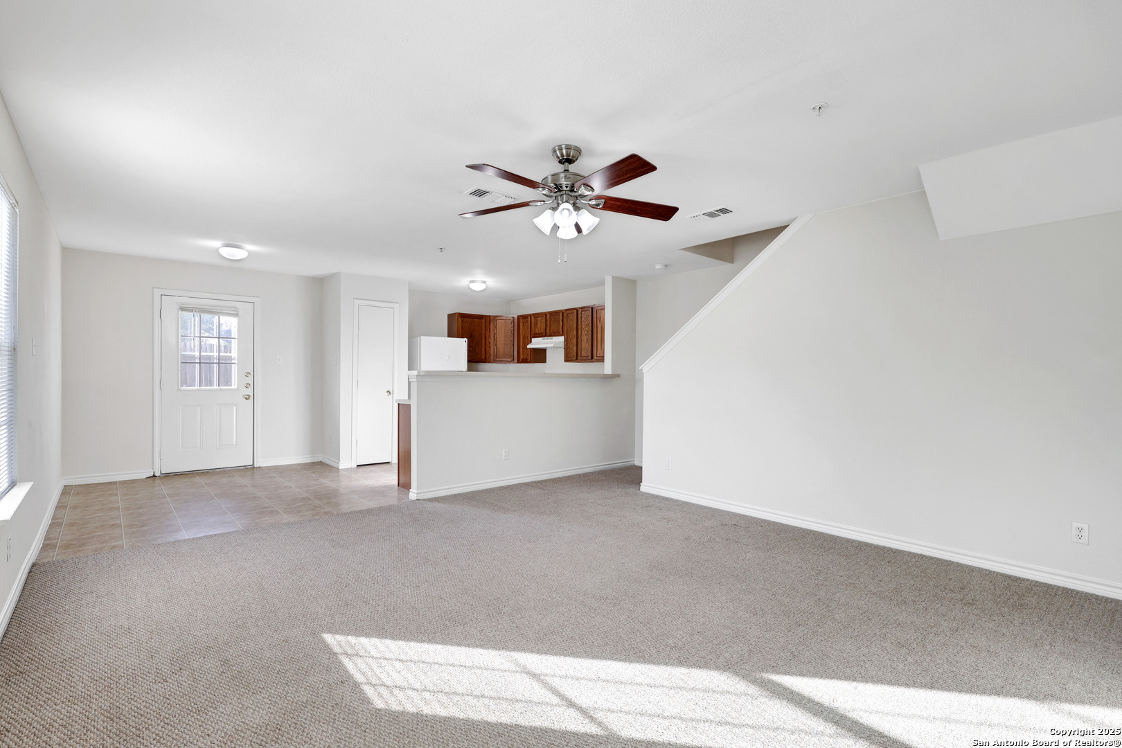 10023 Vasso View, Unit 1 Converse, TX 78109 - Photo 4 of 27 a view of a livingroom with a ceiling fan window and a kitchen