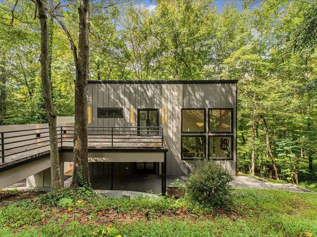 a view of a wooden chairs and table in the back yard