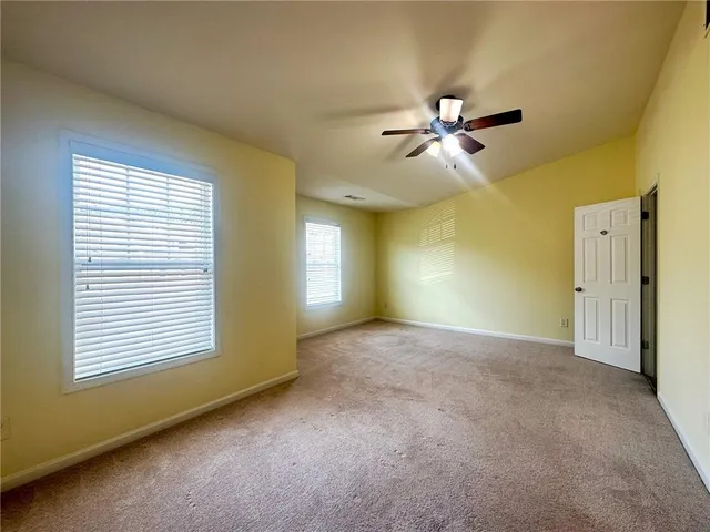 a view of a room with a ceiling fan and a window