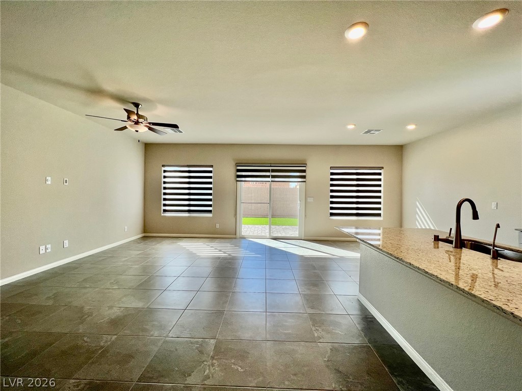 7845 Morganite Avenue Las Vegas, NV 89113 - Photo 8 of 21 A well-lit, open-concept living area with durable tile flooring and backyard access.