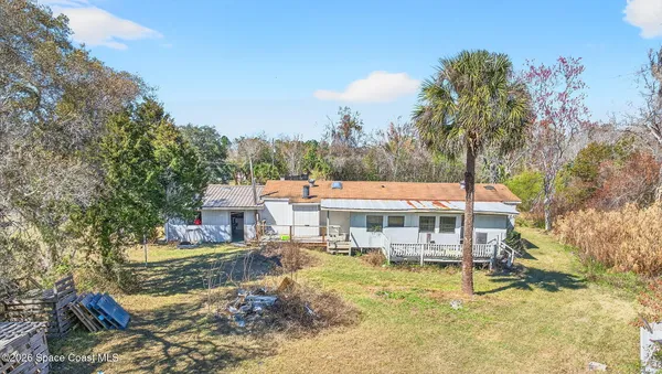 an aerial view of a house with swimming pool and a yard