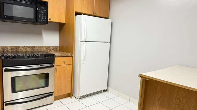 a kitchen with granite countertop a sink stove and refrigerator