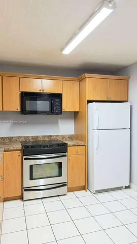 a kitchen with granite countertop sink and cabinets