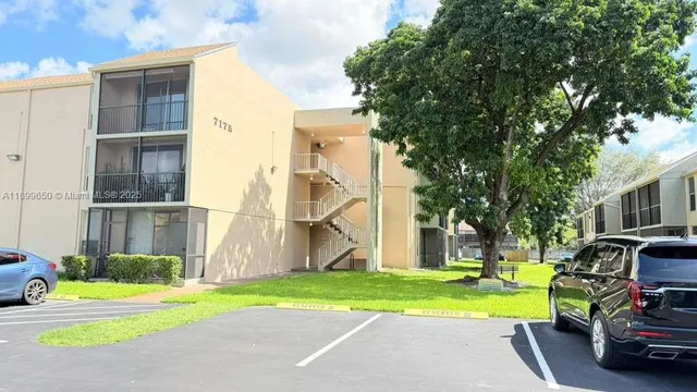 a view of a house with a patio and a yard