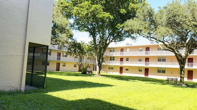 a front view of a house with a yard and palm trees