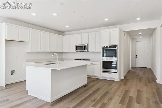 a kitchen with stainless steel appliances granite countertop a stove a sink and a refrigerator