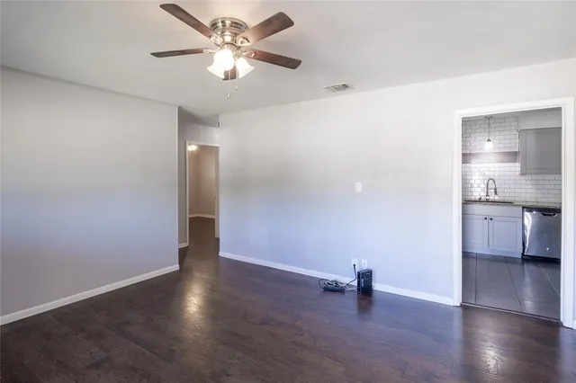 a view of a big room with wooden floor and a ceiling fan