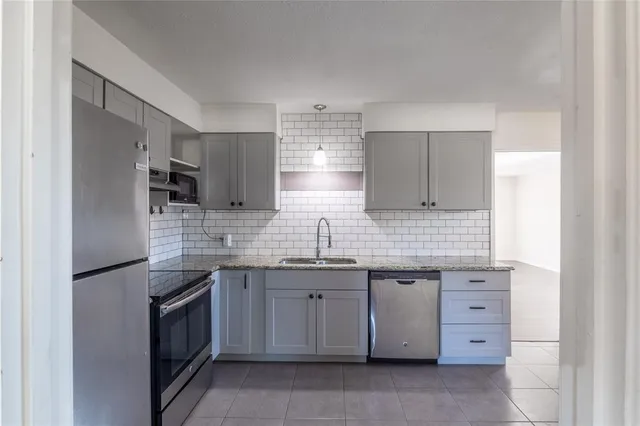 a kitchen with stainless steel appliances granite countertop a sink and cabinets