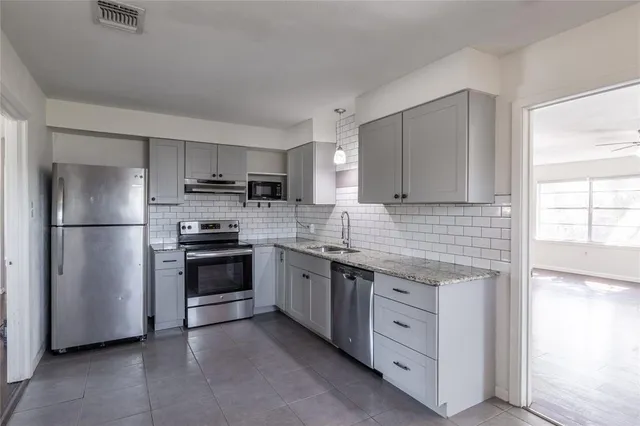 a kitchen with stainless steel appliances granite countertop a refrigerator stove a sink and dishwasher