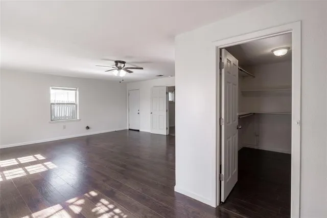 a view of a livingroom with wooden floor and a ceiling fan