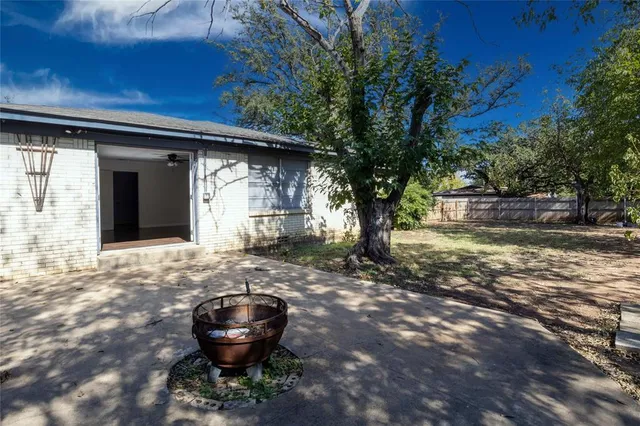 a front view of a house with a large tree