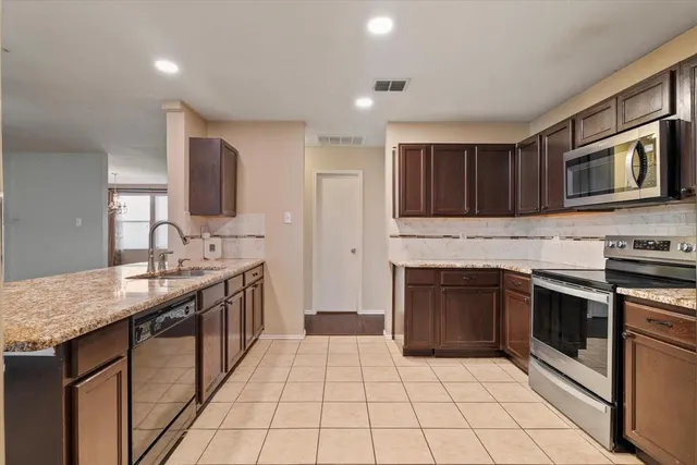 a kitchen with stainless steel appliances granite countertop a stove sink and cabinets