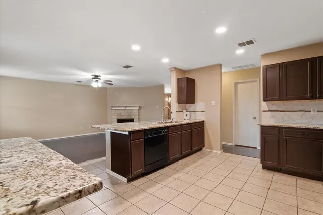 a large kitchen with kitchen island granite countertop a sink and a stove