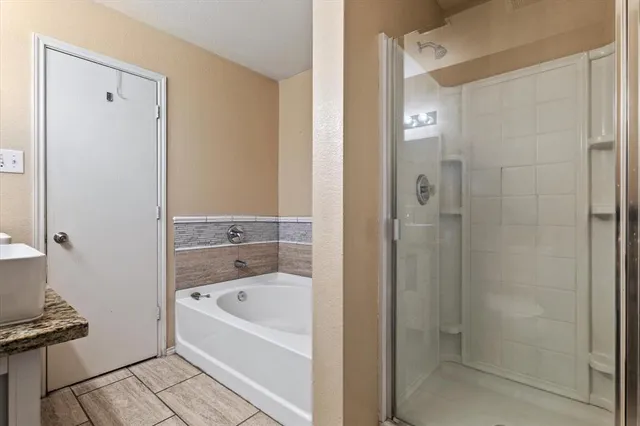 a bathroom with a bathtub shower and sink