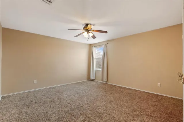 a view of a room with a ceiling fan and a window