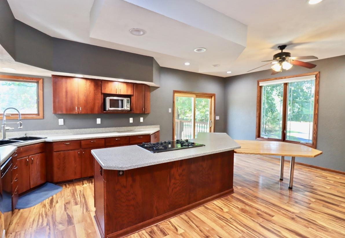 6210 Mc Donald Road Roscoe, IL 61073 - Photo 12 of 41 a kitchen with stainless steel appliances granite countertop wooden cabinets a stove a sink and a large window