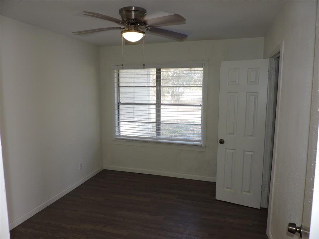 1612 North Anglin Street Cleburne, TX 76031 - Photo 7 of 16 an empty room with wooden floor fan and windows