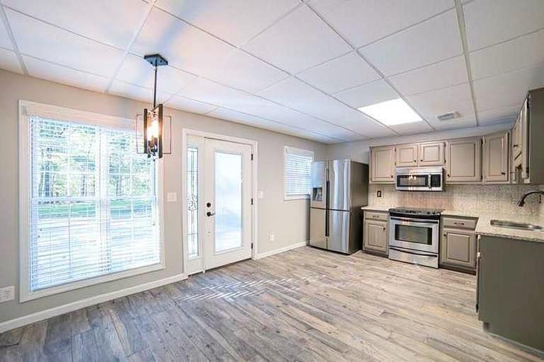 1925 Jesse Cronic Road Braselton, GA 30517 - Photo 43 of 58 a kitchen with stainless steel appliances granite countertop a refrigerator a sink dishwasher a stove and white countertops with wooden floor