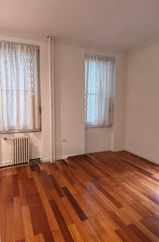 a view of a room with wooden floor and a window