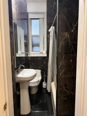 a bathroom with a sink toilet and shower