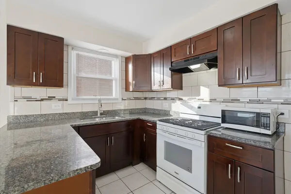 a kitchen with stainless steel appliances granite countertop white cabinets sink stove and granite counter top