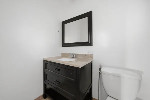 a bathroom with a toilet a sink and mirror