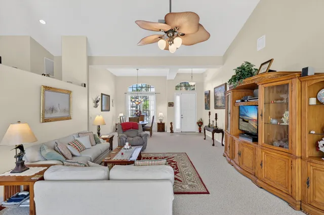 a living room with furniture kitchen view and a large window