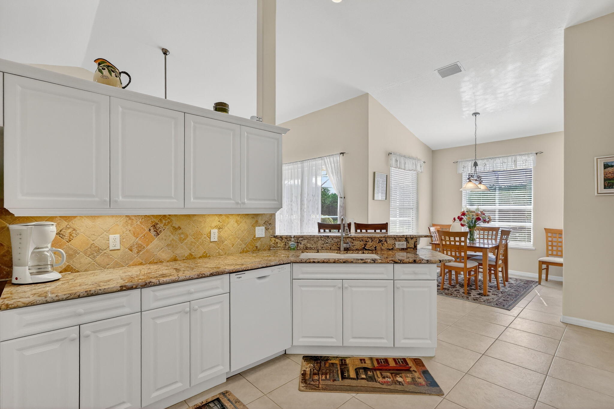 3075 73rd Place Vero Beach, FL 32967 - Photo 14 of 65 a kitchen with granite countertop a sink a stove and cabinets