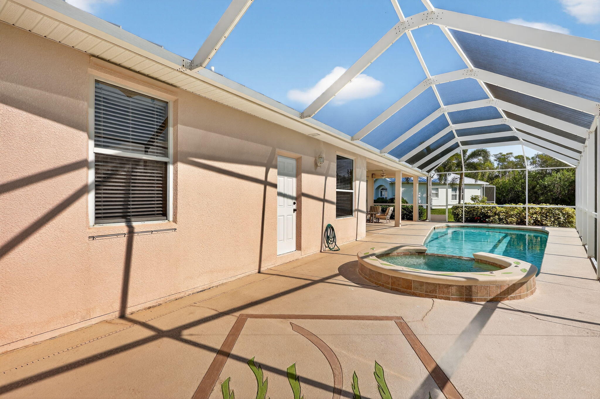 3075 73rd Place Vero Beach, FL 32967 - Photo 35 of 65 a patio with a table and chairs and potted plants