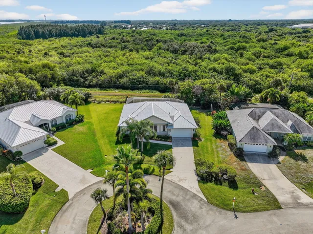 an aerial view of residential houses with outdoor space and trees