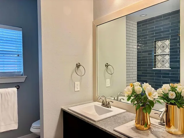 a bathroom with a sink a toilet and mirror