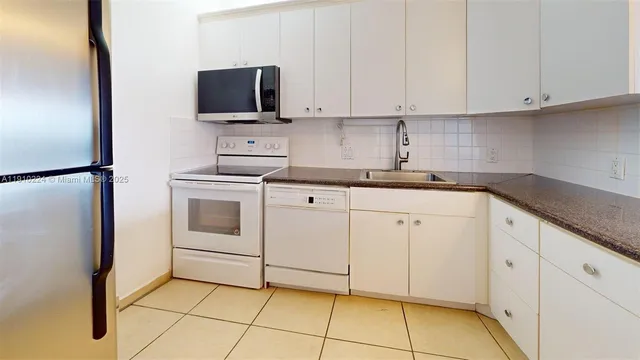 a kitchen with white cabinets and white appliances