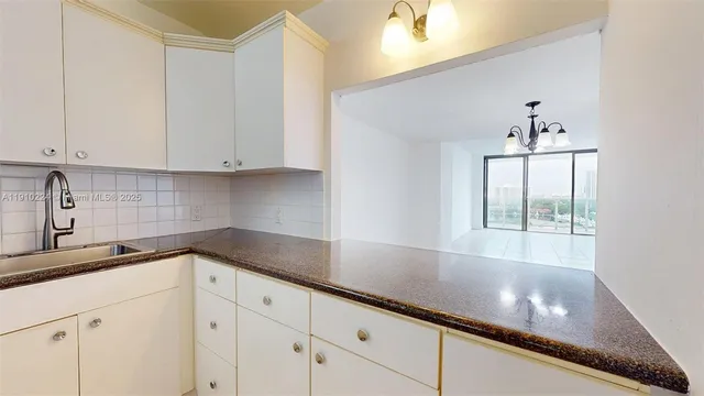 a kitchen with granite countertop white cabinets and white appliances